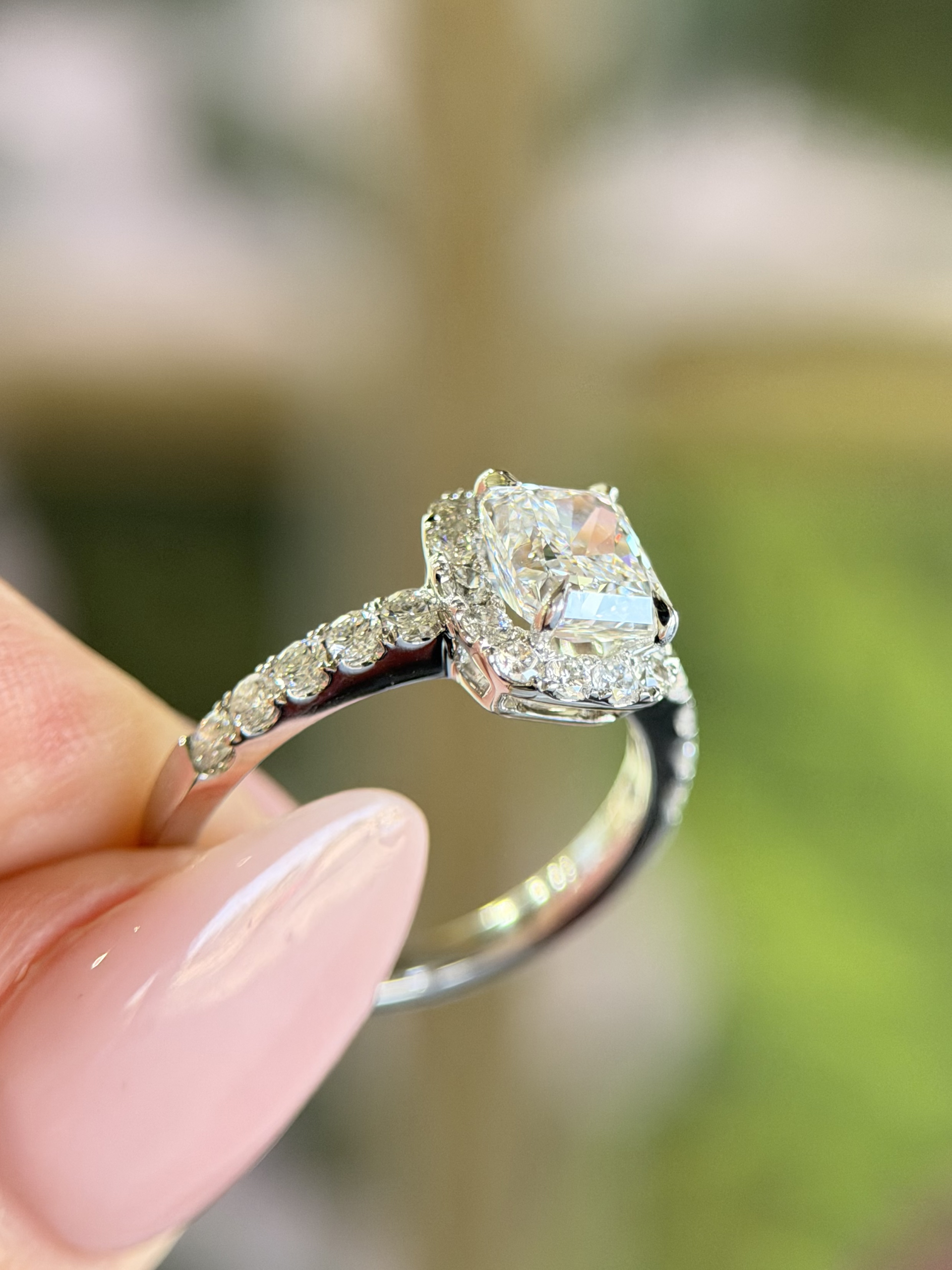 Cushion cut diamond halo engagement ring held by hand — Myranda Fine Jewelry Chandler AZ